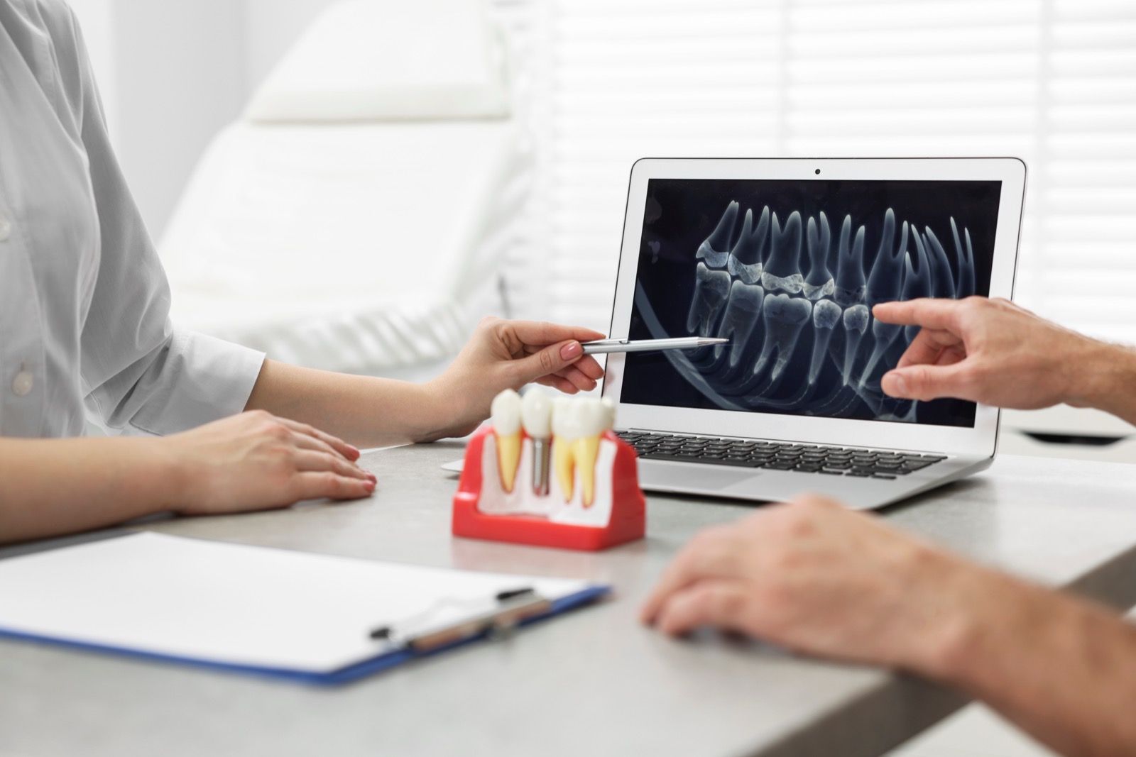 A dentist reviewing an X-ray with a patient